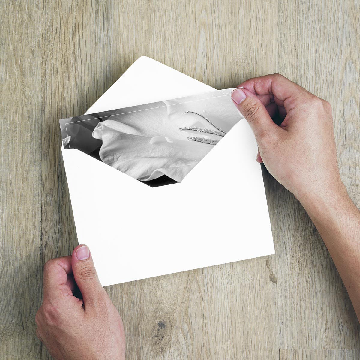 Weißer Umschlag mit hochwertiger, nachhaltiger Trauerkarte im minimalistischen Design, schwarz-weißes Foto sichtbar.